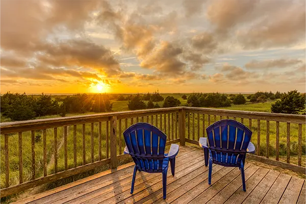 Two chairs on a deck - sun setting