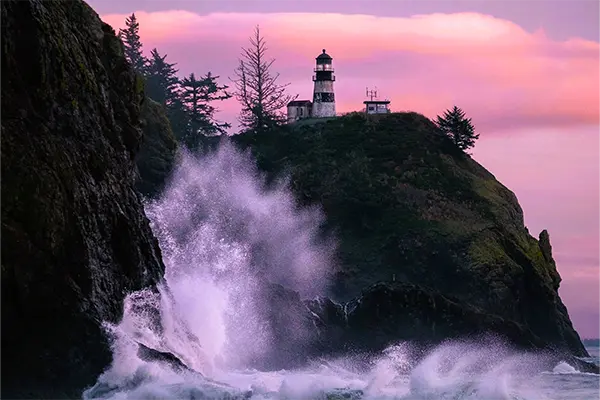 Waves crashing on the coast by a lighthouse